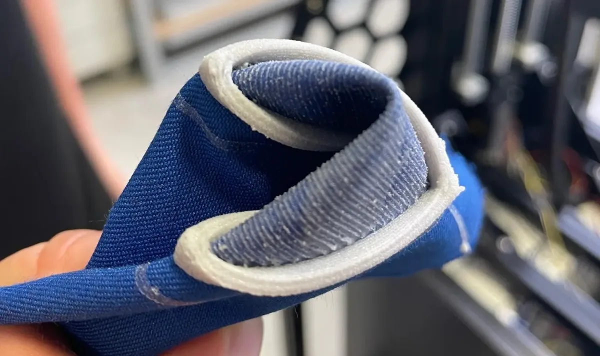 Flexible, im 3D-Druck gefertigte TPE-Kante direkt auf eine blaue Textilmanschette gedruckt – additive Fertigung auf Textilien bei der S2S Systemdrucker GmbH